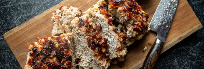 maple bacon meatloaf sliced thick on a cutting board