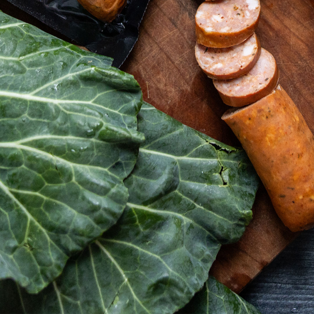 kale and north country smokehouse andouille style sausage on a cutting board