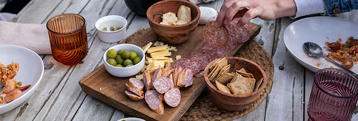 outdoor summer dinner table at night, people lingering, North Country Smokehouse salami charcuterie board