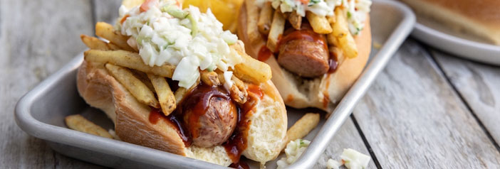 charred kielbasa hoagie topped with vinegar slaw, fries and BBQ sauce on a toasted roll